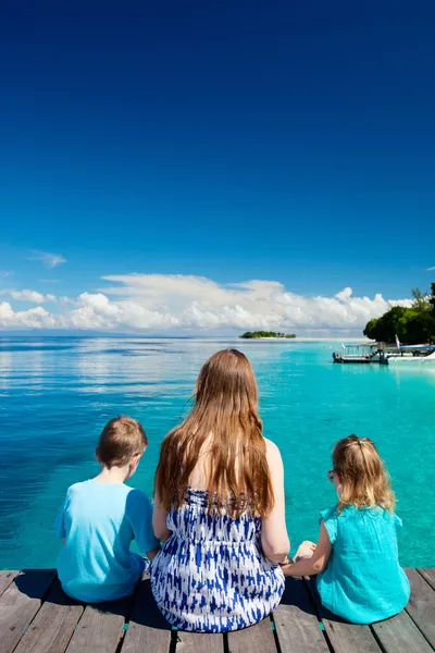 Anne ve çocuklar tahta iskelede oturup — Stok fotoğraf