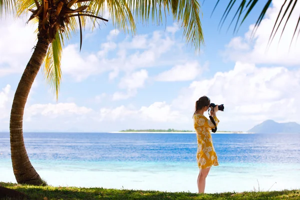 Mujer joven tomando fotos en la playa — Foto de Stock