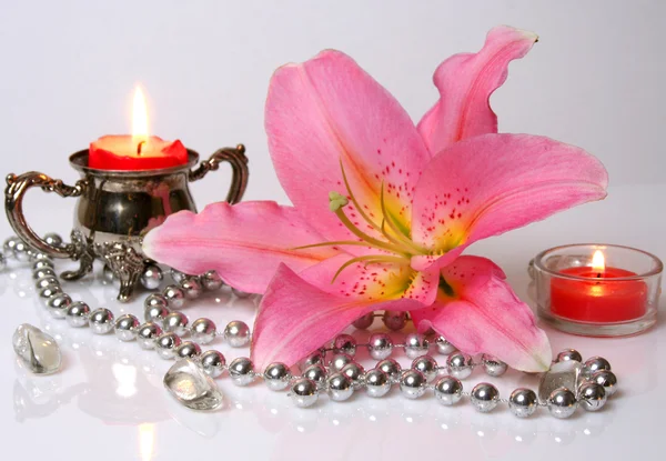 Roze lily en kaarsen — Stockfoto