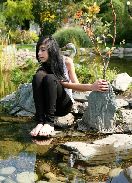 Het meisje, zittend op een steen — Stockfoto