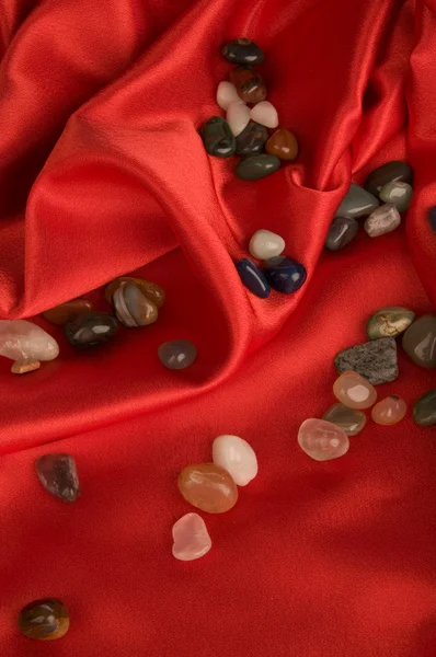 Color precious stone on red silk — Stock Photo, Image