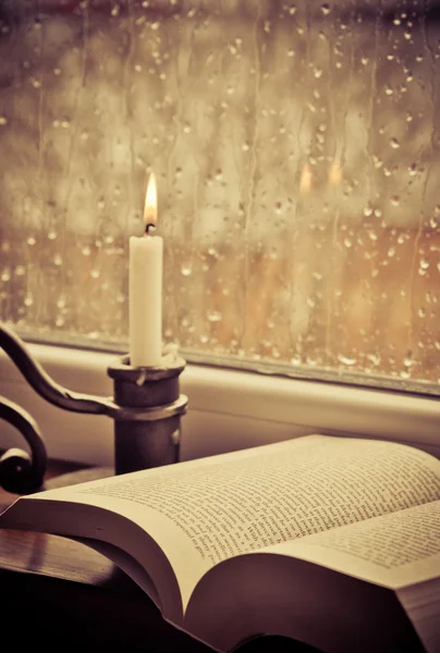 孔雀の形一本书和一支蜡烛在下雨天 — 图库照片