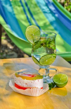 Breakfast outdoors: delicious fruit cake and cold mojito clipart