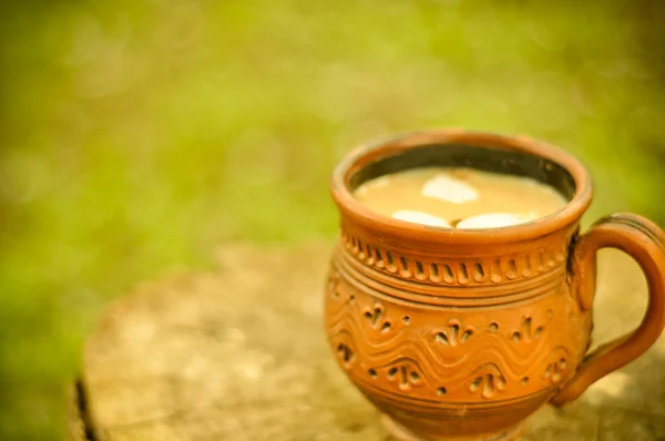 Кофе со сладким молоком в руке глиняный кубок — стоковое фото