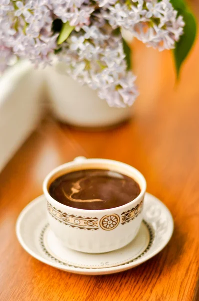 Керамическая чашка с кофе и букет сирени — стоковое фото