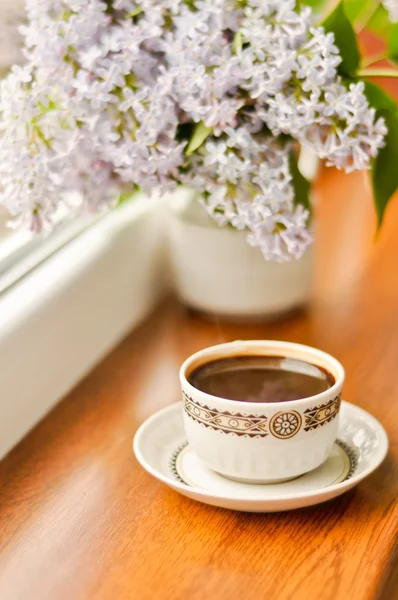 Ceramic cup with coffee and bouquet of lilac — Stock Photo, Image