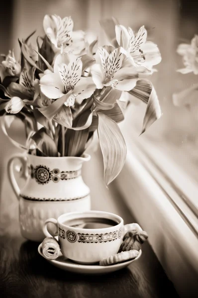 Sepia: Ceramic cup with coffee and bouquet of alstroemeria — Stock Photo, Image