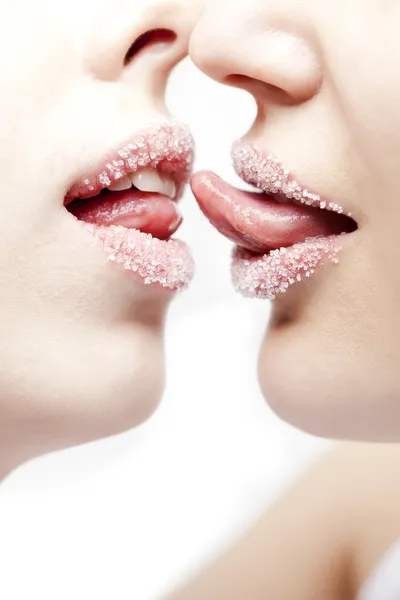 Closeup of pair girl lips and tongues with sugar powder - Stock Image. 