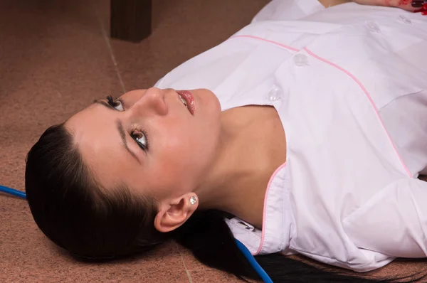 犯罪シーンのシミュレーション。床に横になっている看護師 — ストック写真