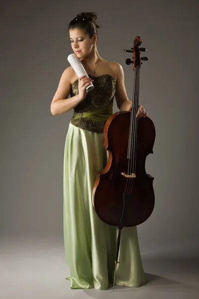 Красивая женщина с виолончелью и счетом — стоковое фото
