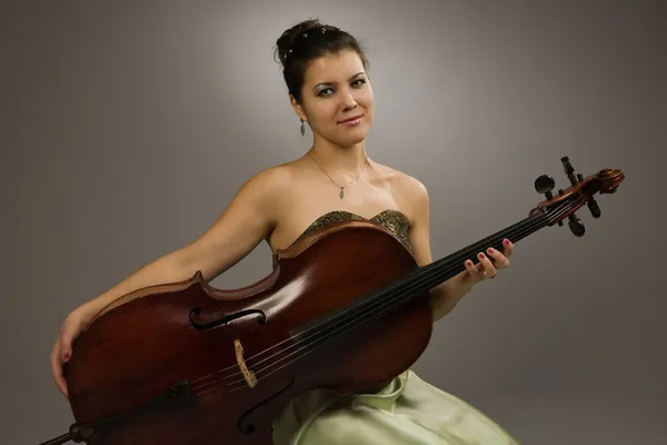 Mujer atractiva sentada con violonchelo — Foto de Stock