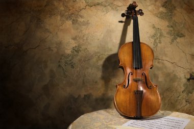 Old italian violin on a wall backround clipart