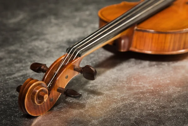 Close-up picture of the old violin on a silver fabric — Stock Photo, Image