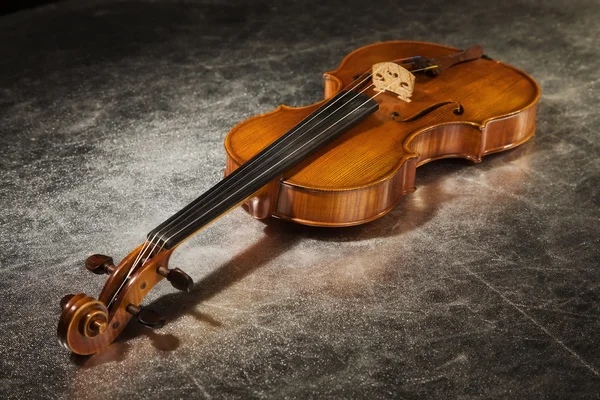 Old violin on a silver fabric — Stock Photo, Image