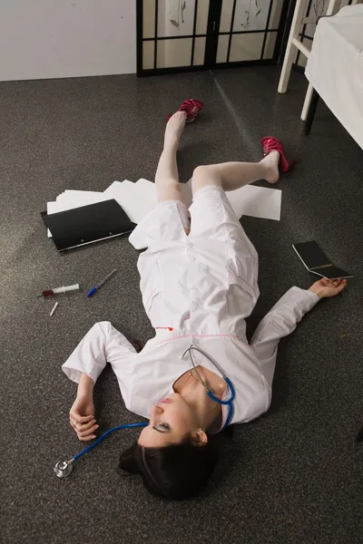 Verpleegkundige op de vloer liggen — Stockfoto