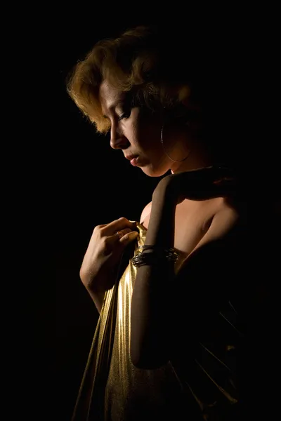 Blonde vrouw in goud stof — Stockfoto