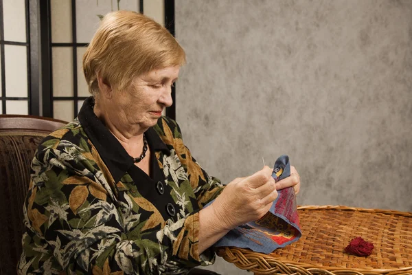 Bir iğne ve iplik ile yaşlı kadın — Stok fotoğraf