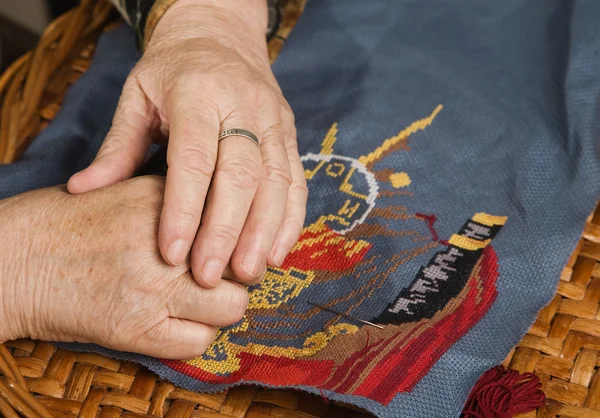Стара жінка рука вишиває ниткою — стокове фото