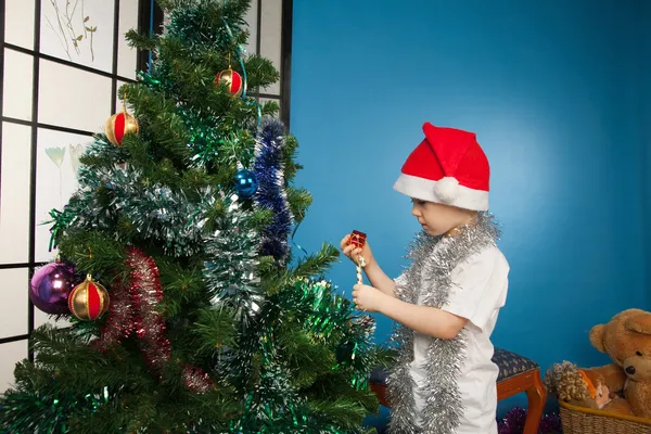 Niño usando ropa de Santa Claus con un regalo de año nuevo — Foto de Stock