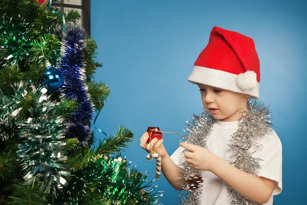 Jongen dragen van santa claus kleding met een nieuwe jaar cadeau — Stockfoto