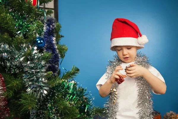 Chlapec nosí santa claus oblečení s novoroční dárek — Stock fotografie