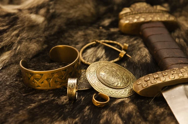 Натюрморт со скандинавскими драгоценностями и мечом на мехе — стоковое фото