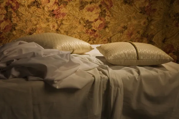 Chaotický neustlaná postel polštář a přikrývka krytem — Stock fotografie