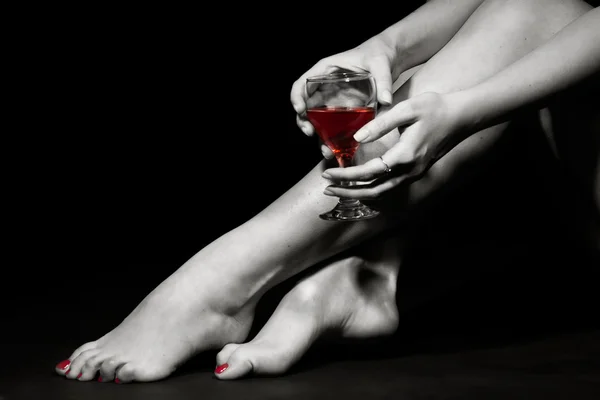 Belle fille jambes et un verre de vin rouge — Photo