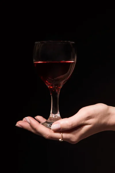 Copa con un vino tinto en una mano femenina — Foto de Stock