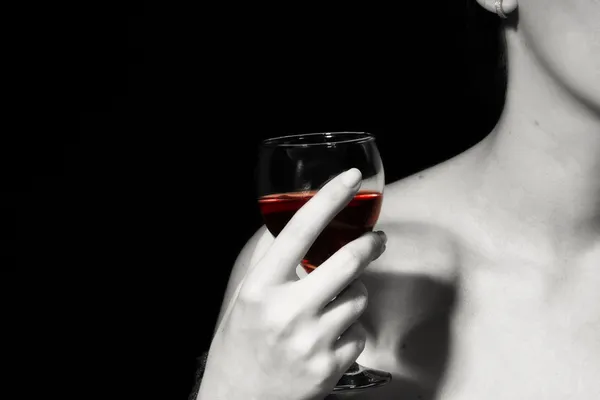 Vinho tinto em uma mão feminina — Fotografia de Stock