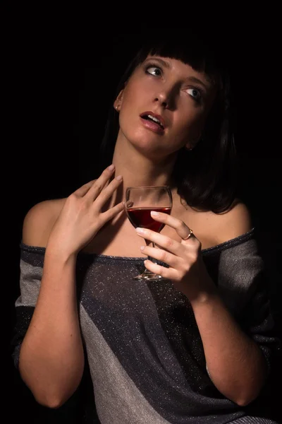 Vinho tinto em uma mão feminina — Fotografia de Stock