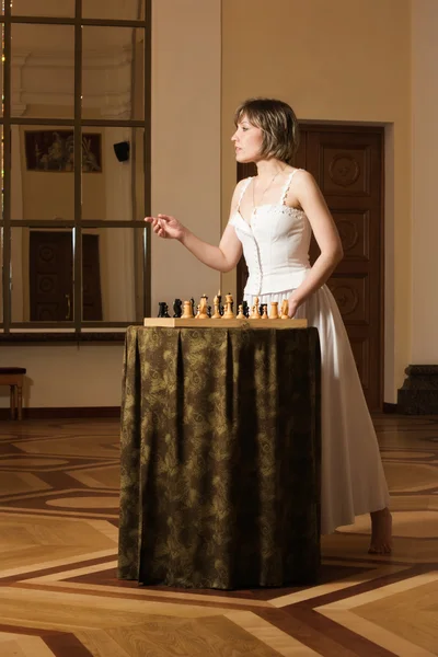 Młoda kobieta grać w szachy w bogate wnętrze — Zdjęcie stockowe