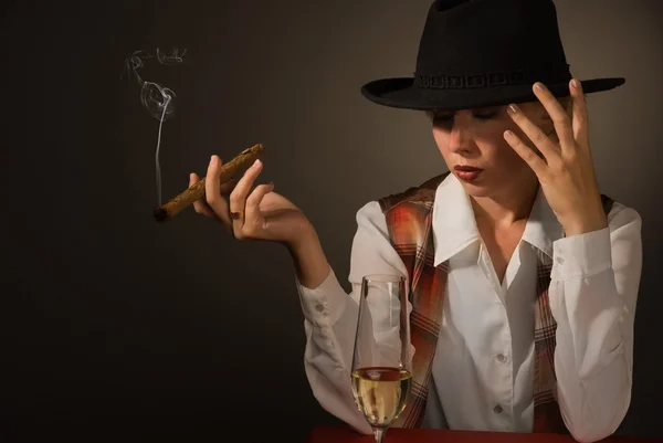 Красивая женщина в черной шляпе с сигарой — стоковое фото