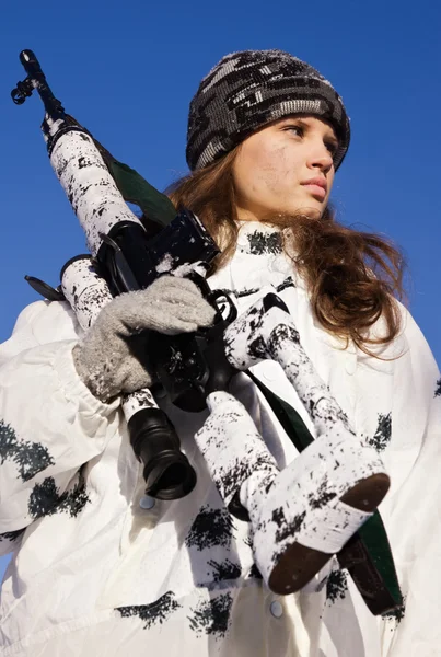 Niña francotirador en camuflaje blanco sobre un fondo azul cielo — Foto de Stock