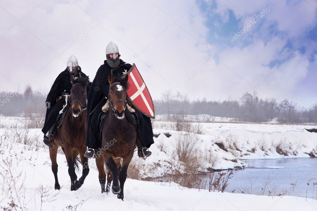 Medieval knights of St. John (Hospitallers) riding on a horses