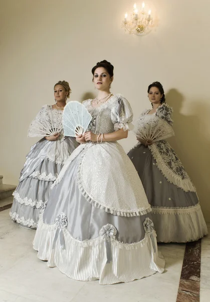 stock image Three young women in ball gowns