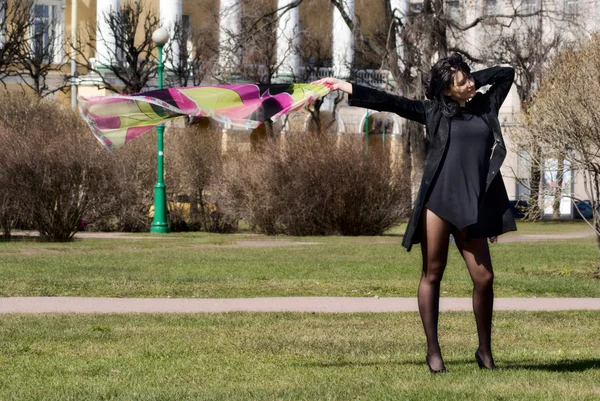 Hermosa mujer con un pañuelo ondeante en un parque de primavera —  Fotos de Stock