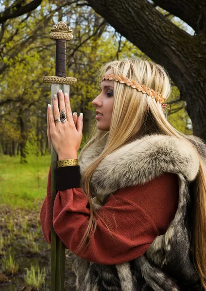 Девушка-викинг с мечом в лесу — стоковое фото