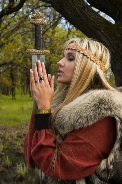 Viking menina com espada em uma floresta — Fotografia de Stock