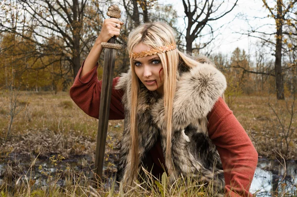Viking girl med svärd i en dimma trä — Stockfoto