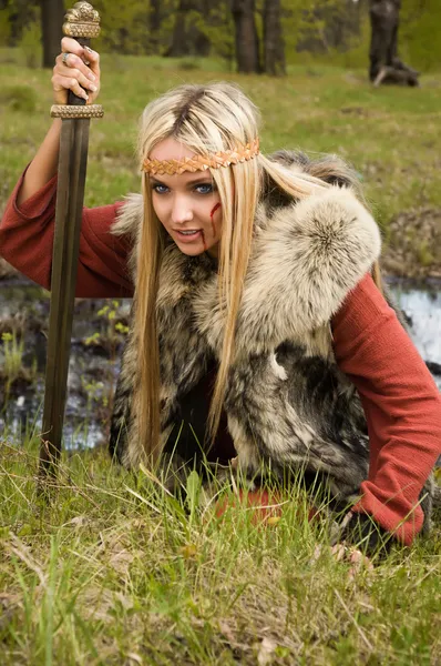 Viking girl med svärd i en trä — Stockfoto