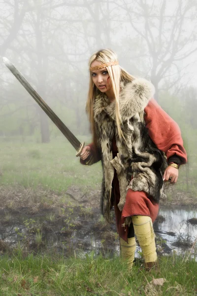 Chica vikinga con espada en un bosque de niebla —  Fotos de Stock