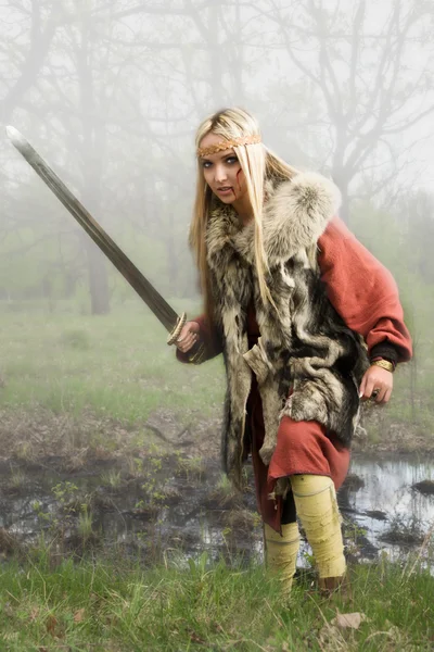 Viking girl with sword in a fog wood — Stock Photo, Image