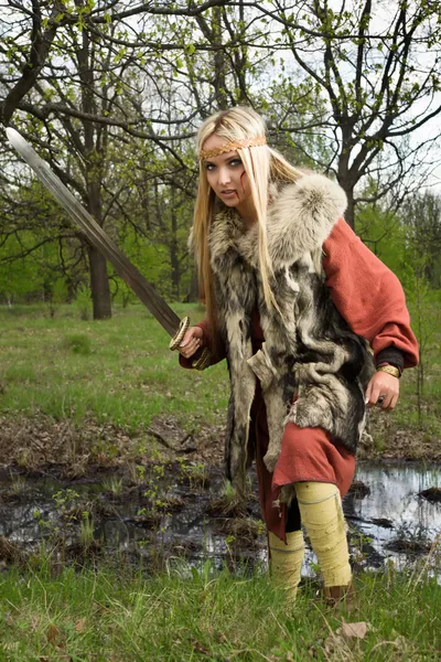 Девушка-викинг с мечом в лесу — стоковое фото