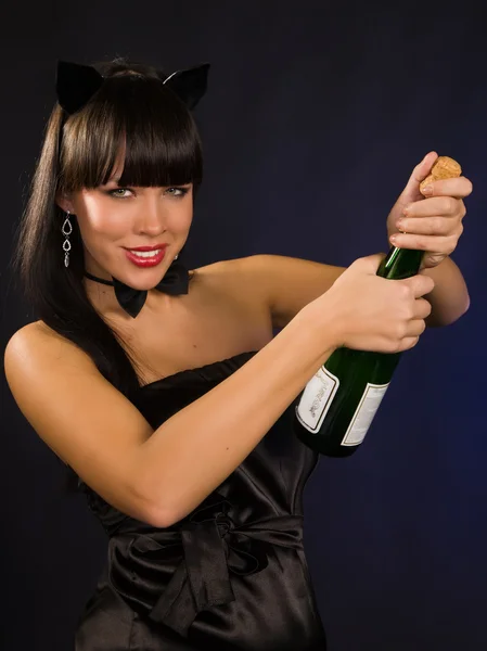 Hermosa mujer con una buttle champán — Foto de Stock