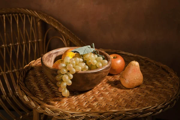 Ahşap bir tabak meyve ile natürmort — Stok fotoğraf