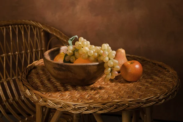 Натюрморт с фруктами в деревянной тарелке — стоковое фото