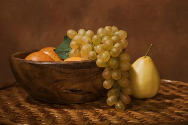 Still-life with fruit in a wooden dish — Stock Photo, Image
