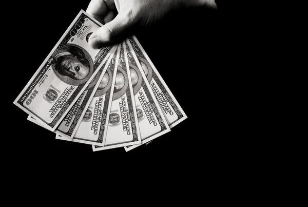 Рука з доларами над чорним — стокове фото