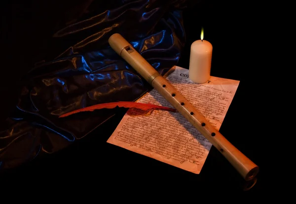 Bodegón con flauta, vela, manuscrito y pluma roja — Foto de Stock